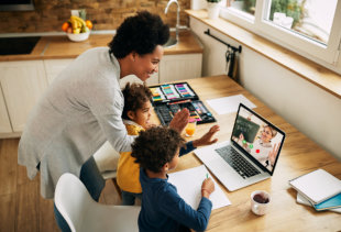 Happy African American family greeting a teacher during a video call over laptop.